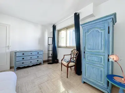 a room with a blue door and a chair at 78m2 Terrasse vue mer à 50m de la Croisette in Cannes