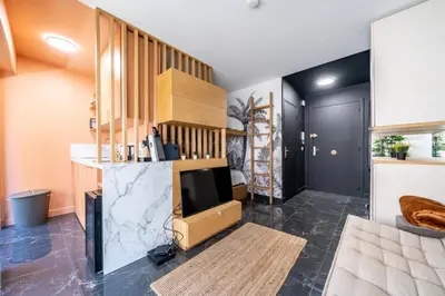 a living room with a tv and a staircase at Sublime studio in the center of Cannes in Cannes