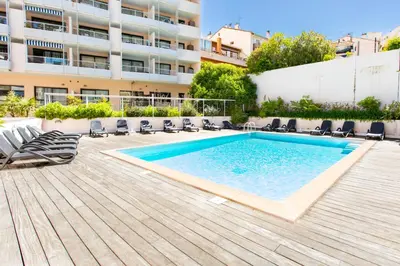 a swimming pool with chairs and a building at Cosy Escape YourHostHelper in Cannes
