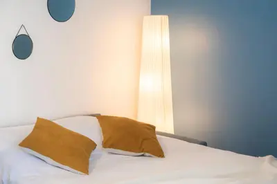 a bedroom with a bed with a pillow and a lamp at Cosy Escape YourHostHelper in Cannes