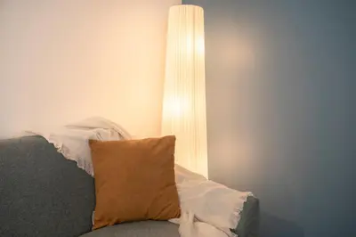 a pillow sitting on a couch next to a lamp at Cosy Escape YourHostHelper in Cannes