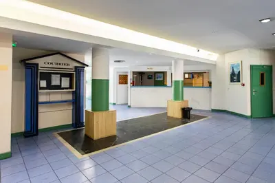 a lobby of a building with columns and a counter at Cosy Escape YourHostHelper in Cannes