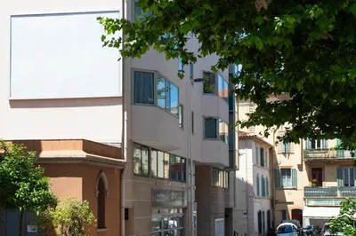 a white building with windows on a city street at Cosy Escape YourHostHelper in Cannes