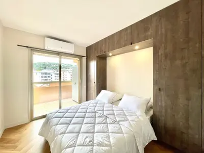 a bedroom with a large bed and a large window at Astoria luxury apartment- 3 bathrooms in Cannes