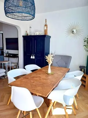 a dining room with a wooden table and white chairs at Charmant 3pièces près de Cannes in Le Cannet