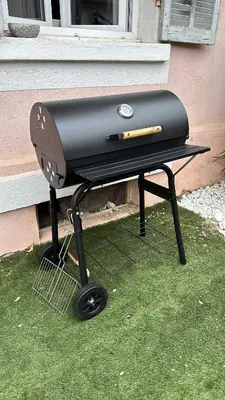 a grill sitting on the grass in front of a house at Charmant 3pièces près de Cannes in Le Cannet