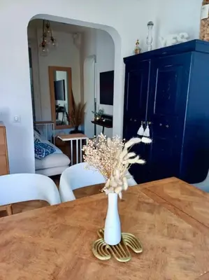 a table with a vase of flowers on a table at Charmant 3pièces près de Cannes in Le Cannet