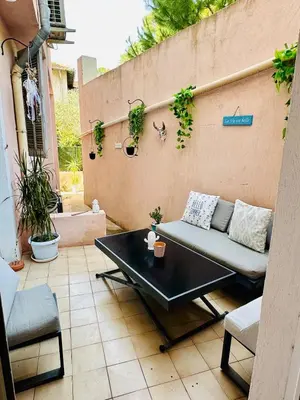 a patio with a couch and a table on a patio at Charmant 3pièces près de Cannes in Le Cannet
