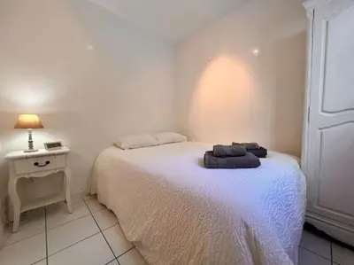 a small bedroom with a bed and a night stand at Cannes Garden Suquet, Terrasse & Garage in Cannes
