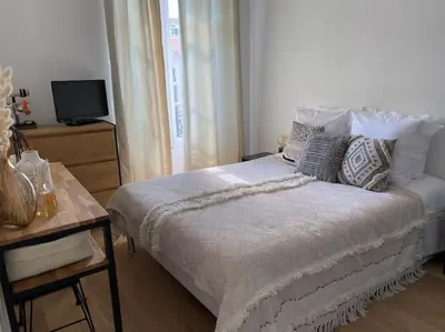 a bedroom with a bed with pillows and a television at Cannes banane, T2 centre ville, 400 m des plages in Cannes