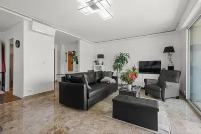 a living room with a black couch and a tv at Cannes Sea View, by Beach, Private Room in Shared 3-Bedroom Apartment, Private Bathroom & Balcony,, Chambre avec salle de bain privative & balcon, chez l'habitant in Cannes