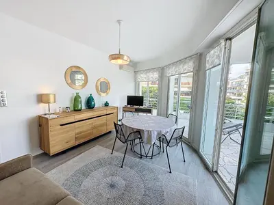 a living room with a table and a couch at ARM1 - Beau 2 pièces avec terrasse d'angle in Cannes