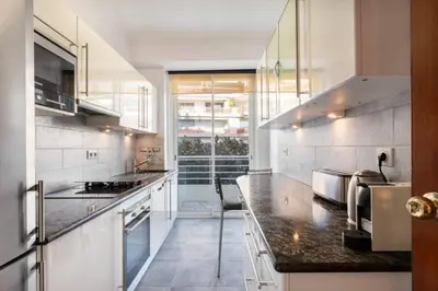 a kitchen with stainless steel appliances and a large window at ARM1 - Beau 2 pièces avec terrasse d'angle in Cannes