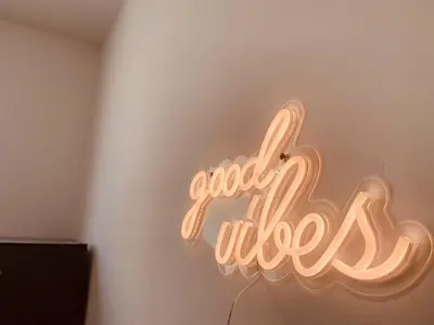 a neon sign that says good vibes on a wall at La Maison by Simone, la vrai in Cannes
