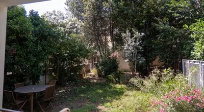 a white building with trees and white flowers at La Maison by Simone, la vrai in Cannes