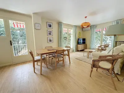 a living room with a wooden table and chairs at 63m2 Grande Terrasse, Clim in Cannes