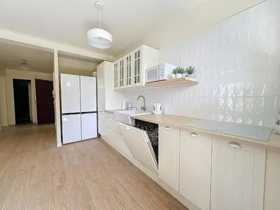a kitchen with white cabinets and a white refrigerator at 63m2 Grande Terrasse, Clim in Cannes