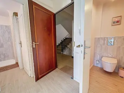 a bathroom with a wooden door and a staircase at 63m2 Grande Terrasse, Clim in Cannes