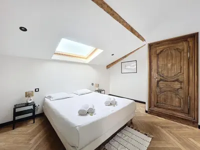 a bedroom with a bed and a wooden door at 140m2 vue mer, 3 chambres, centre-ville in Cannes