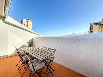 a wooden table and chairs sitting on a balcony at 140m2 vue mer, 3 chambres, centre-ville in Cannes