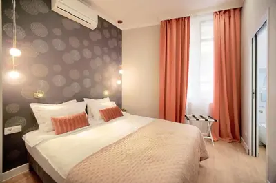 a bedroom with a large white bed with orange curtains at Marigold - 2 Bed 2 bath - AC - 8 min from Palais in Cannes