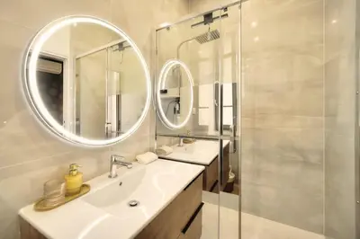 a bathroom with a sink and a mirror at Marigold - 2 Bed 2 bath - AC - 8 min from Palais in Cannes