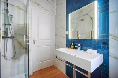 a bathroom with a white sink and a mirror at Marigold - 2 Bed 2 bath - AC - 8 min from Palais in Cannes