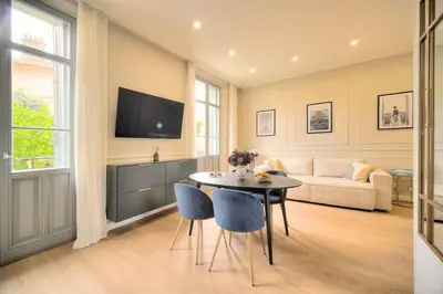 a living room with a table and a couch at Marigold - 2 Bed 2 bath - AC - 8 min from Palais in Cannes