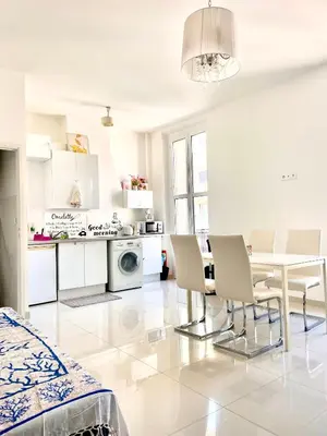 a white living room with a table and chairs at Cannes plage 2 pièces Croisette centre ville in Cannes