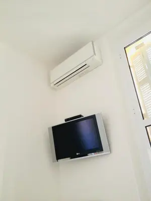 a flat screen tv on a wall in a room at Cannes plage 2 pièces Croisette centre ville in Cannes