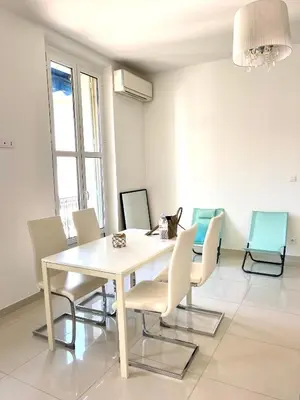 a dining room with a white table and chairs at Cannes plage 2 pièces Croisette centre ville in Cannes
