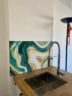 a kitchen with a sink and a painting on the wall at Appartamento coeur du Suquet in Cannes