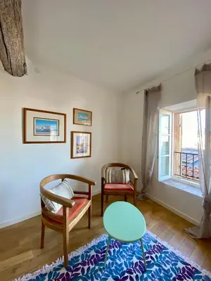 a living room with a table and chairs and a window at Appartamento coeur du Suquet in Cannes