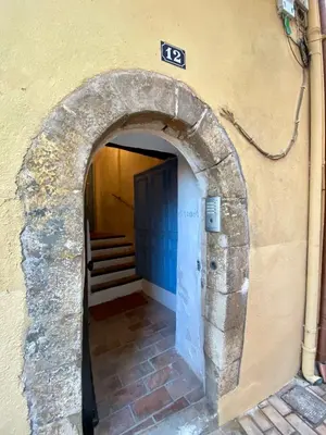 an archway leading into a building with a blue door at Appartamento coeur du Suquet in Cannes