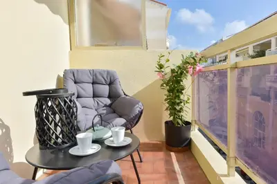a small balcony with a chair and a table at Apartment with Terrace walk to Beaches & Shopping in Cannes