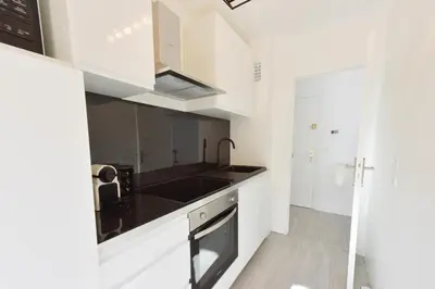 a kitchen with white cabinets and black counter tops at Apartment with Terrace walk to Beaches & Shopping in Cannes