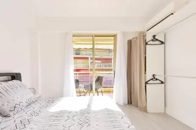 a white bedroom with a bed and a balcony at Apartment with Terrace walk to Beaches & Shopping in Cannes