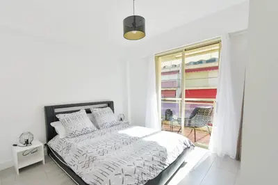 a white bedroom with a bed and a window at Apartment with Terrace walk to Beaches & Shopping in Cannes