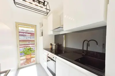 a white kitchen with a sink and a window at Apartment with Terrace walk to Beaches & Shopping in Cannes