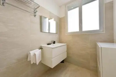 a bathroom with a white sink and a window at 1-bedroom apartment walk to beach garage in Cannes