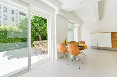 a dining room with a table and chairs and sliding glass doors at 1-bedroom apartment walk to beach garage in Cannes