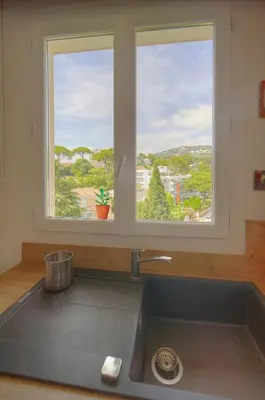 a kitchen counter with a sink and two windows at FRGK Isola Bella ' Appartement Confortable' in Cannes