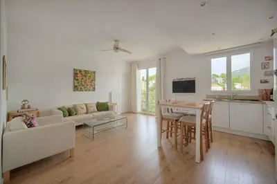 a white living room with a table and a couch at FRGK Isola Bella ' Appartement Confortable' in Cannes