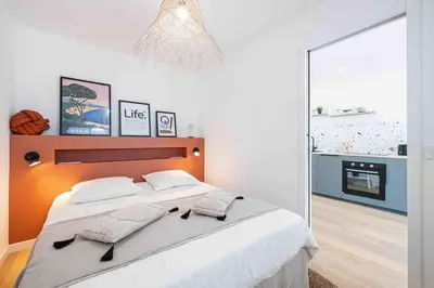 a bedroom with a large bed and a mirror at 2 pièces cosy en centre ville in Cannes