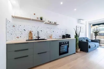 a kitchen with a counter and a blue couch at 2 pièces cosy en centre ville in Cannes