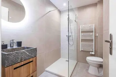 a bathroom with a toilet and a glass shower at 2 pièces cosy en centre ville in Cannes