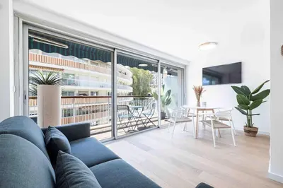 a living room with a blue couch and a table at 2 pièces cosy en centre ville in Cannes