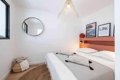 a bedroom with a large bed with a mirror at 2 pièces cosy en centre ville in Cannes