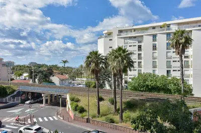 a building with palm trees in front of a street at Rare luxury 3-Br near the Croisette in Cannes