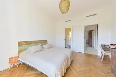 a white bedroom with a large bed and a desk at Rare luxury 3-Br near the Croisette in Cannes